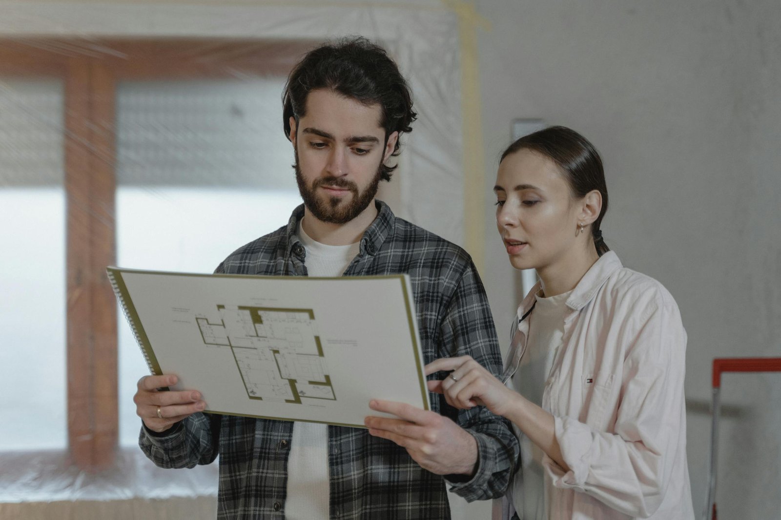 Couple reviewing home renovation floor plan — planning a home project with dumpster rental in Owensboro